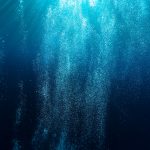 Immagine subacque di bollicine che salgono nel blu dell'acqua marina